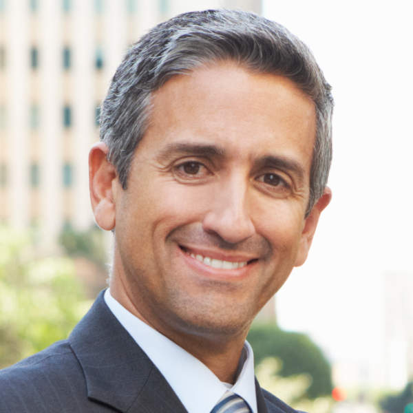 Smiling professional man in suit outdoors with city background.